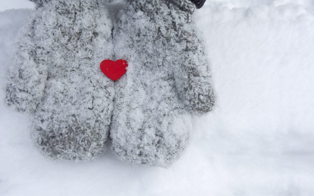 Snowy mittens with tiny red heart. Valentine’s concept.